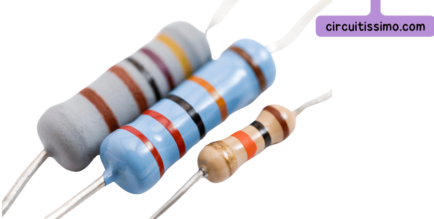 Trois résistances électroniques de différentes tailles et couleurs, montrant leurs bandes de couleur indicatives.